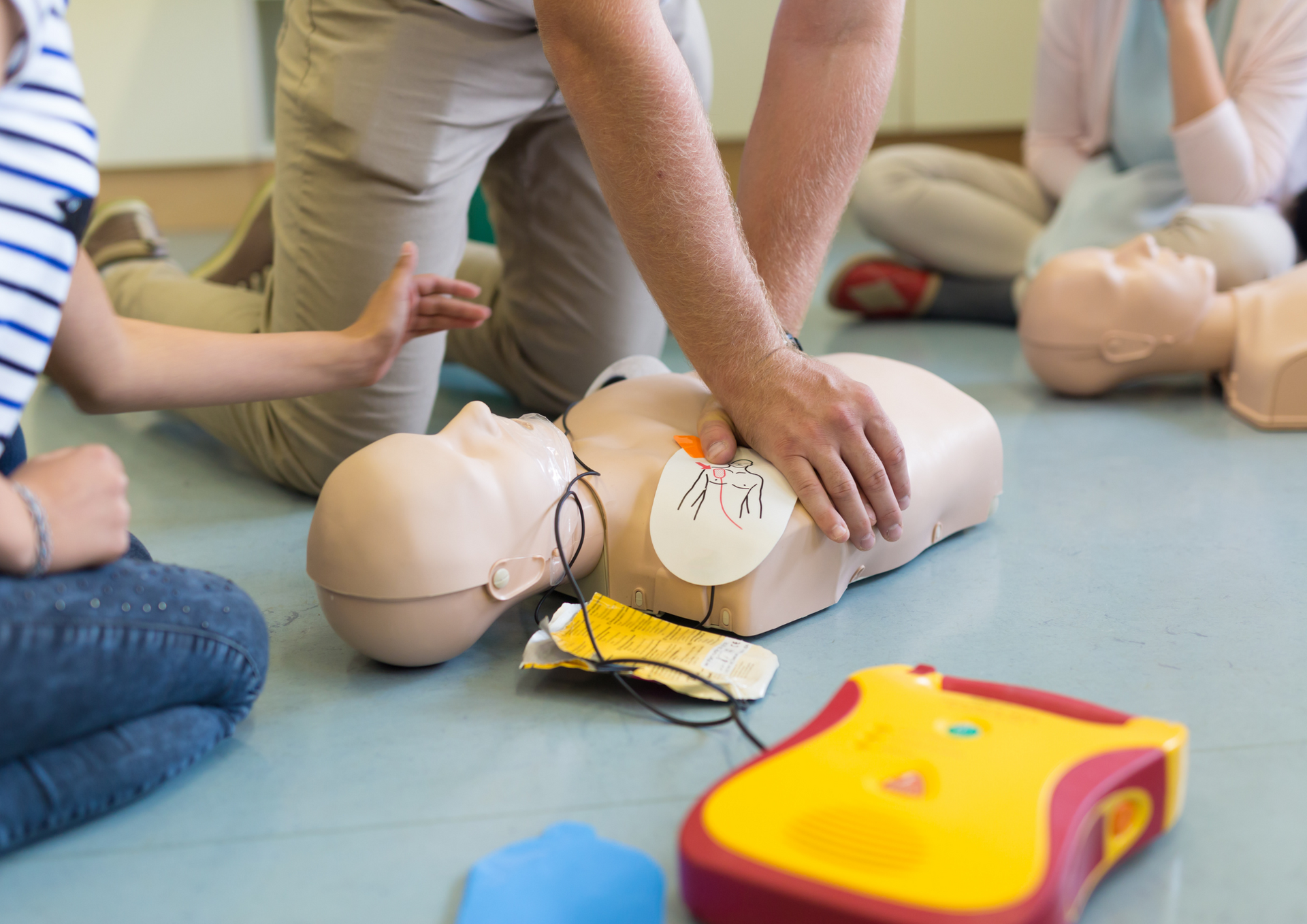 Bild Erste Hilfe Eine Erste Hilfe Puppe und Personen, die auf der Puppe üben